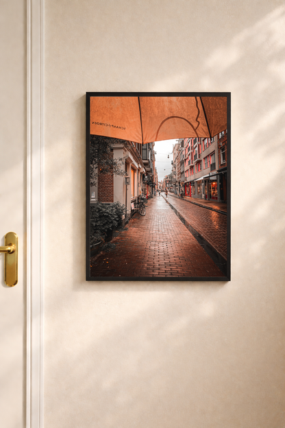 Amsterdam wall art featuring a rain soaked street scene with warm reflections after rainfall.