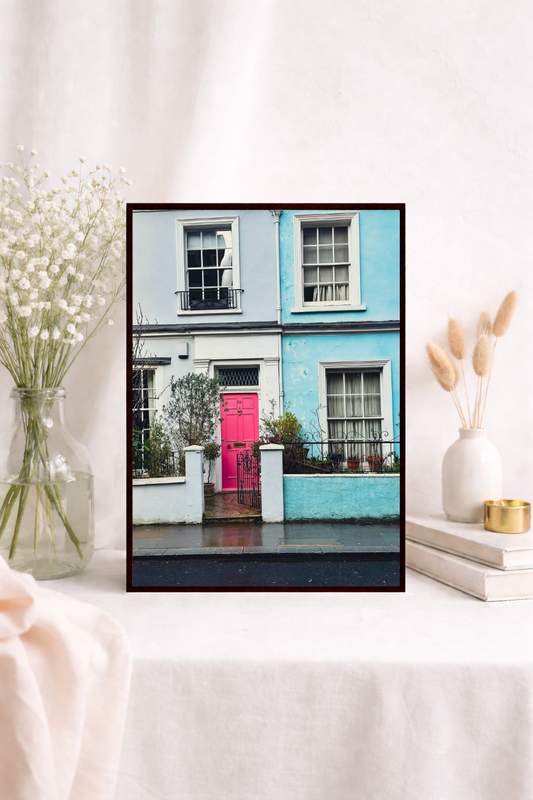Colourful wall art featuring a bright pink door and pastel houses in London.