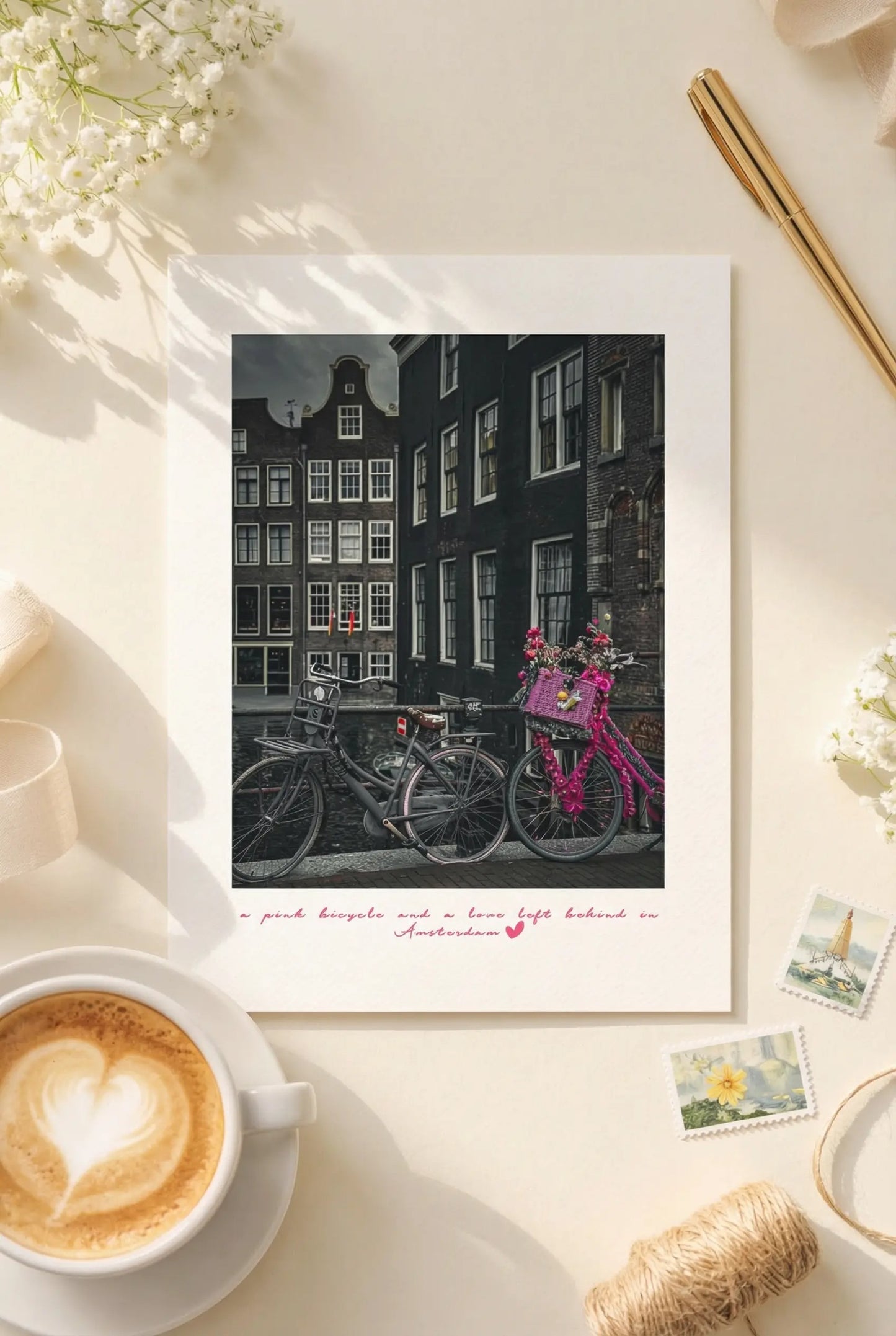 Amsterdam postcard featuring a vintage pink bicycle beside canal houses.